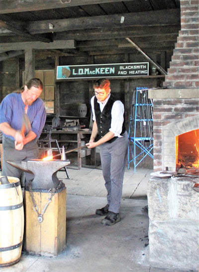 Two men working in the blacksmith shop