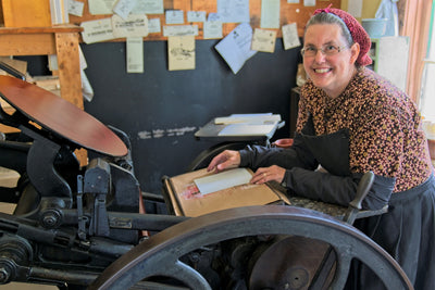 A woman works with the printing press