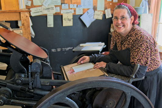 A woman works with the printing press