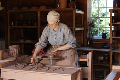 A woman working with a pottery wheel