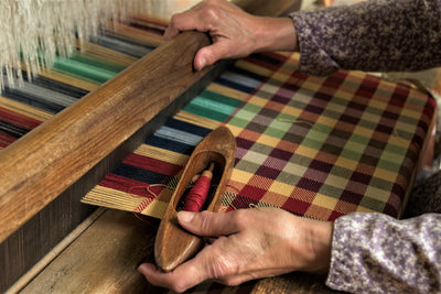 A woman's hands weave a tablecloth