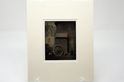 Matted Ambrotype Photo - Wooden Wagon Wheel leaning up against building